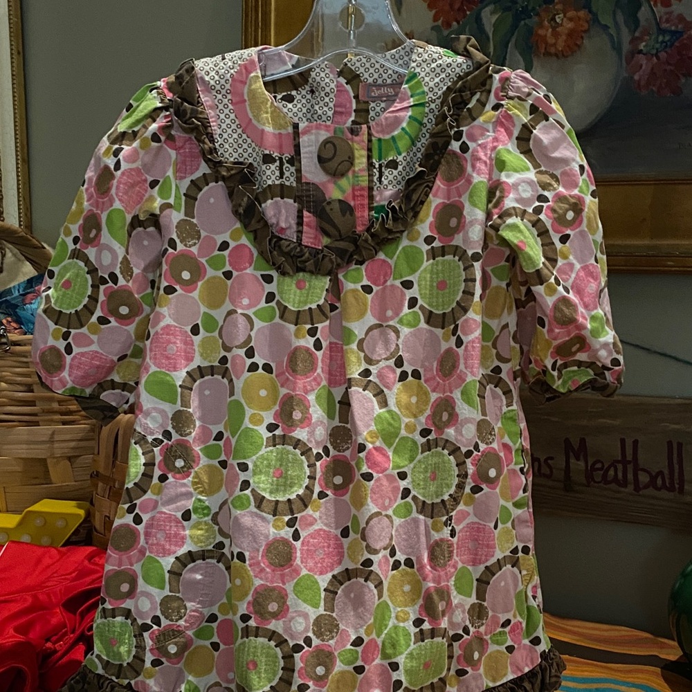 Jelly the Pug Montros girls' dress with a colorful floral and polka dot pattern.